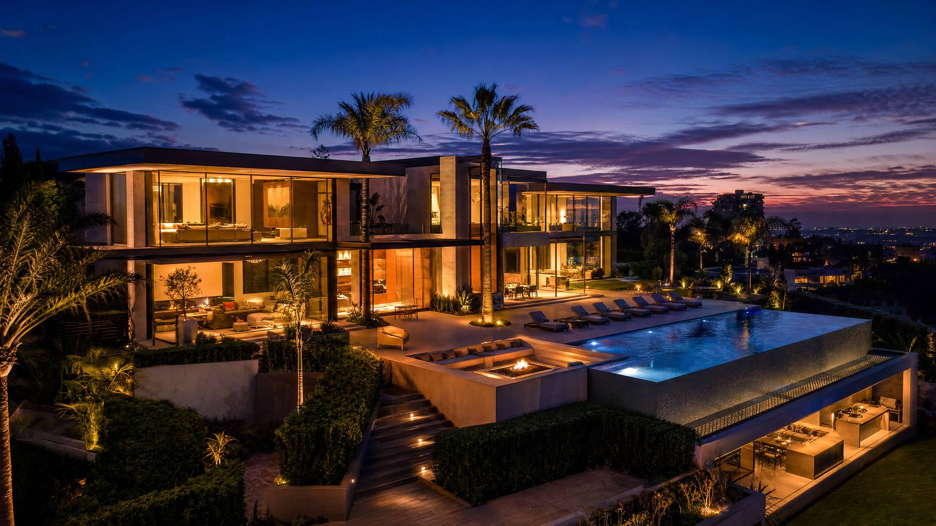 Luxury modern mansion at twilight with infinity pool and dramatic lighting